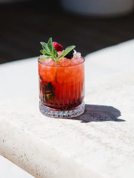 Cocktail fruits rouges du bar Indie Beach Ramatuelle, servi sur comptoir en travertin