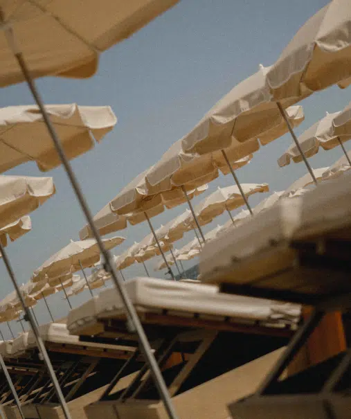 Parasols et transats de la plage privée Indie Beach Pampelonne vus en contre-plongée