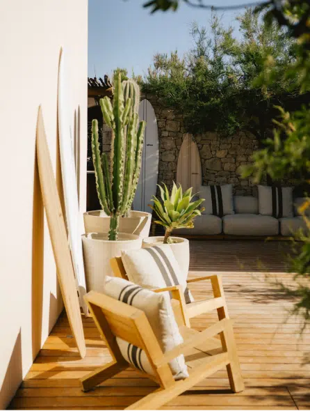 Espace d&eacute;tente bord de plage Pampelonne, fauteuil teck, cactus et planches de surf